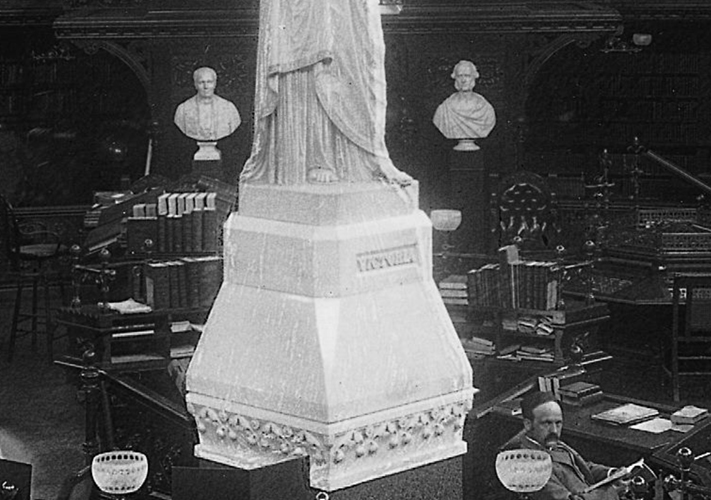 Cropped black and white photograph showing the inside the Library in about 1895. The sculpted marble busts of Marble busts of Sir Étienne-Paschal Taché and John Sandfield Macdonald can be seen in the background.