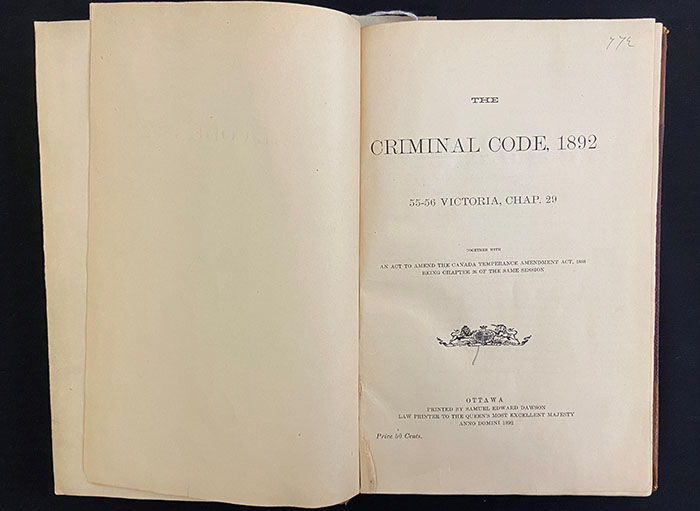 An old book, The Criminal Code, 1892, open at the title page.